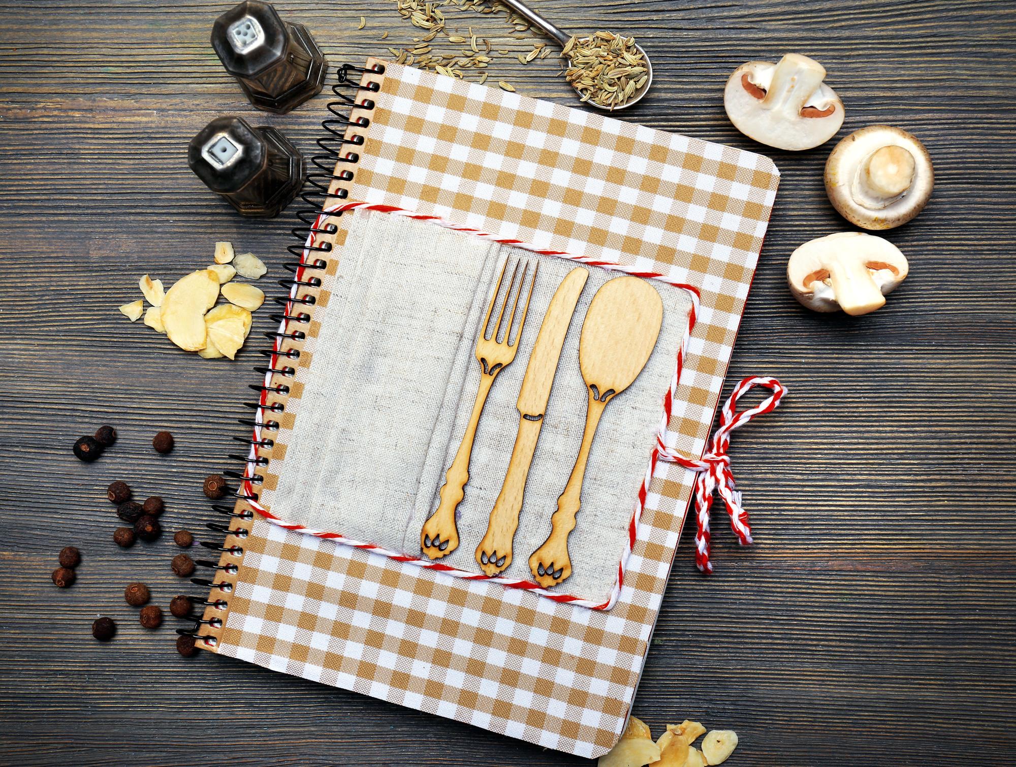 Stack of recipe notebooks and brass tools